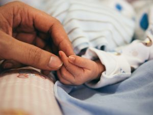 parent tenant la main d'un bébé