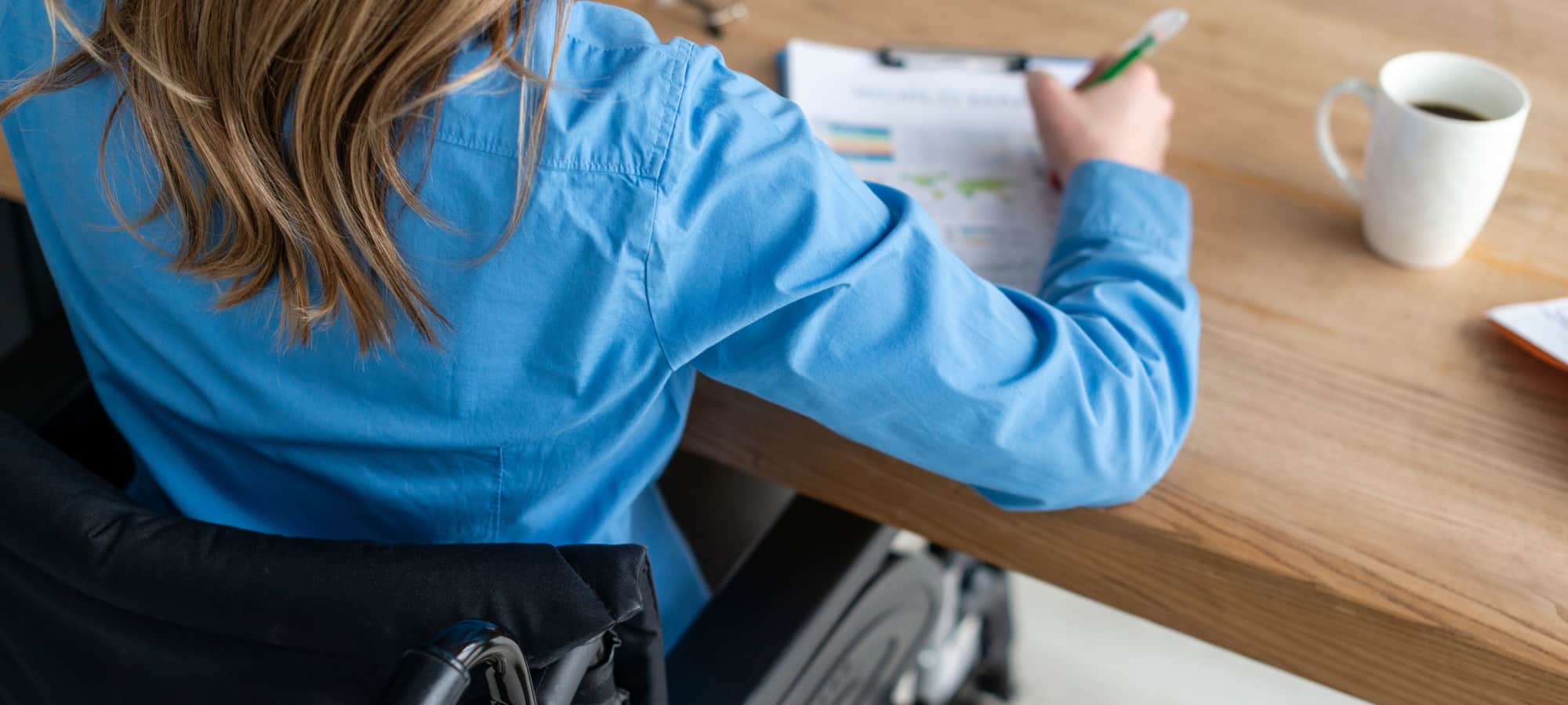 Personne en fauteuil roulant remplissant une demande d'allocation Vierge Noire en Belgique