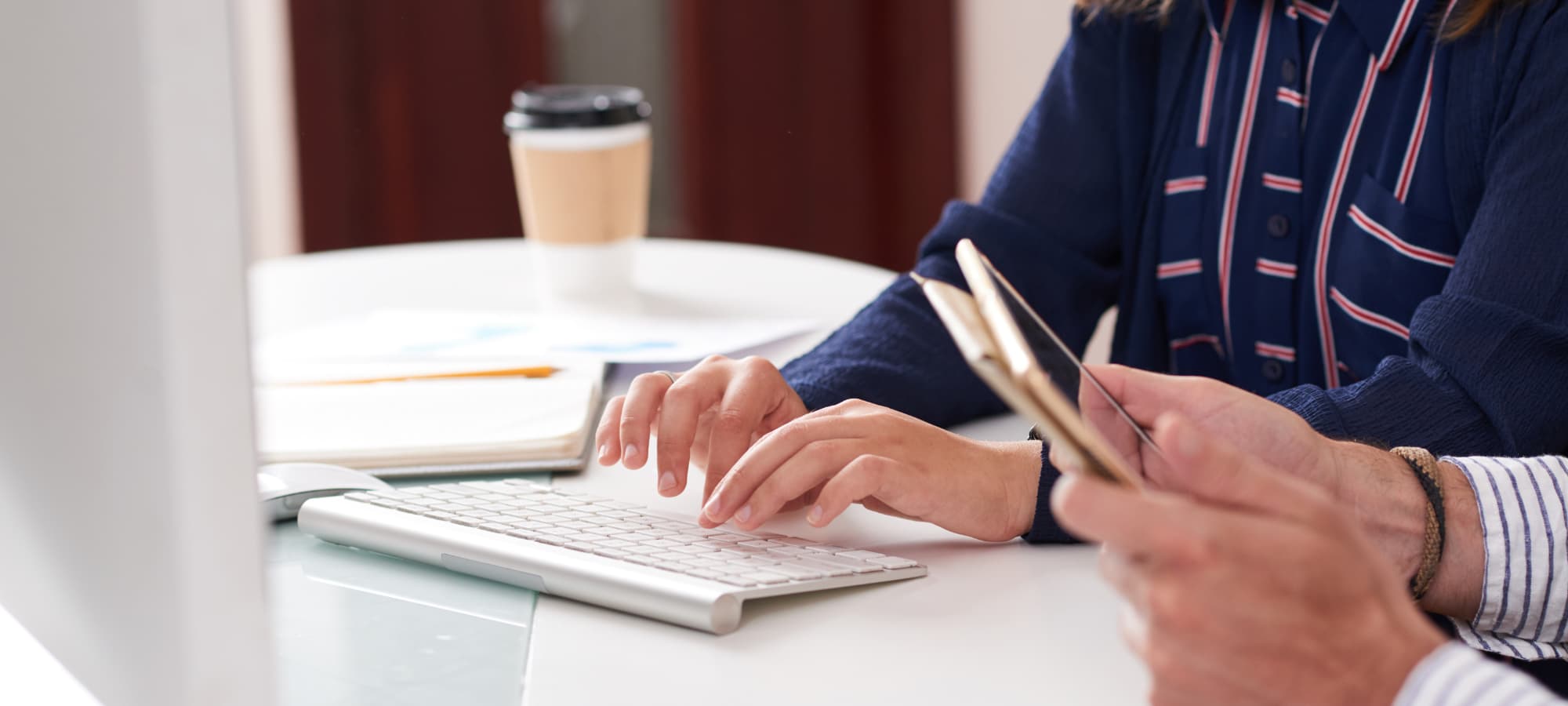 Personne effectuant ses démarches d'inscription à la CAPAC sur ordinateur avec documents administratifs