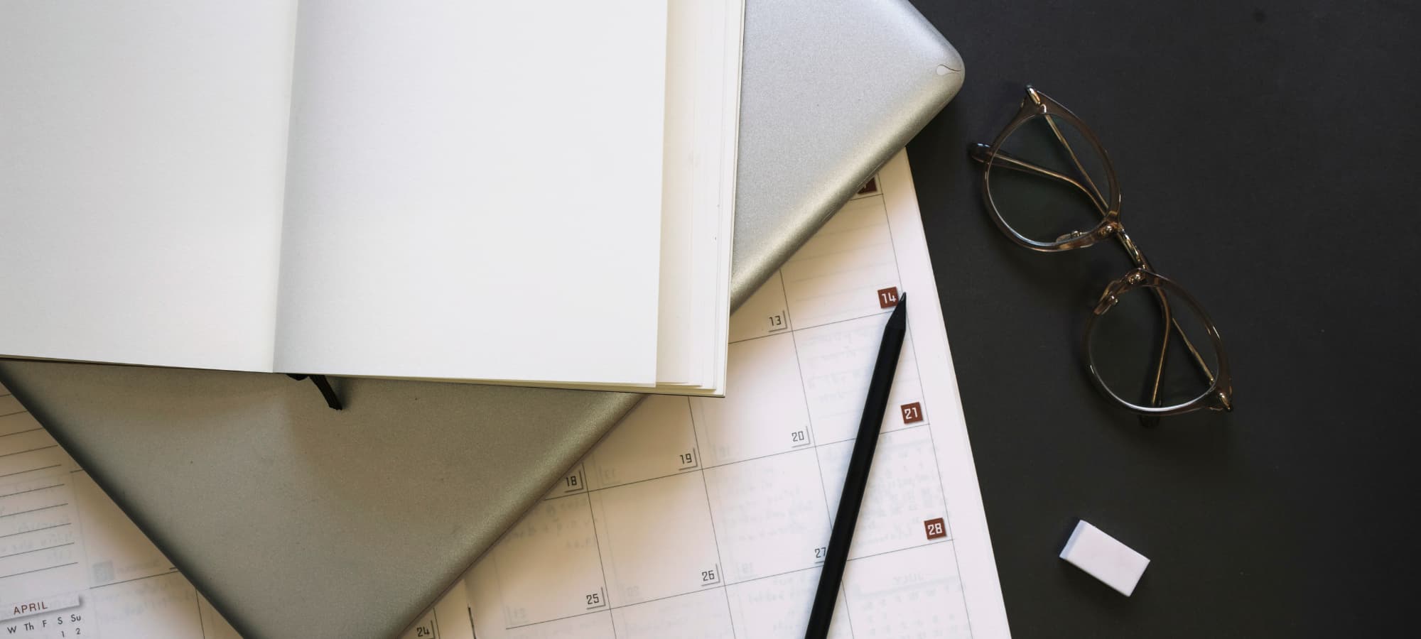 Agenda ouvert avec calendrier et ordinateur illustrant les dates de paiement du chômage FGTB en 2026 en Belgique