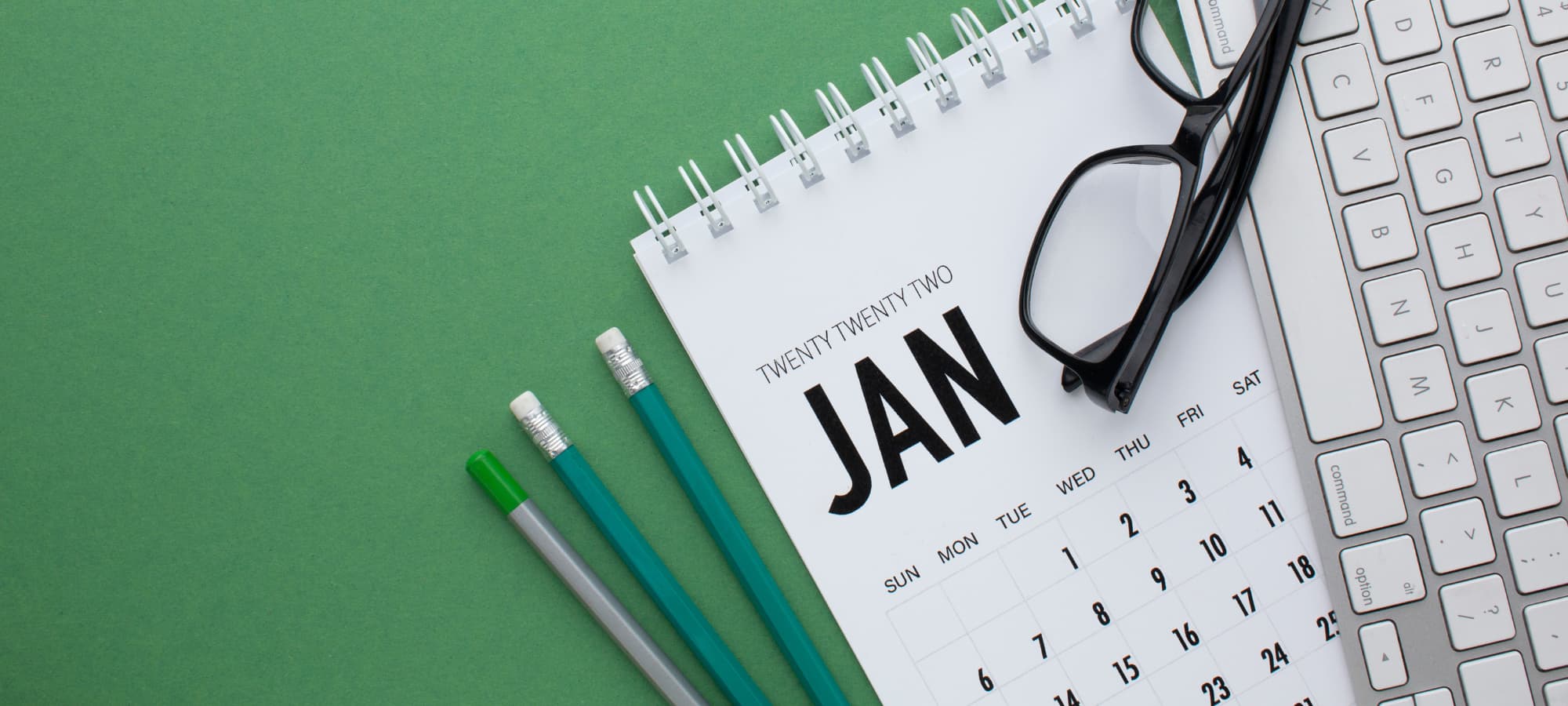 Calendrier mensuel sur un bureau illustrant les dates de paiement du RIS versé par le CPAS en 2026 en Belgique