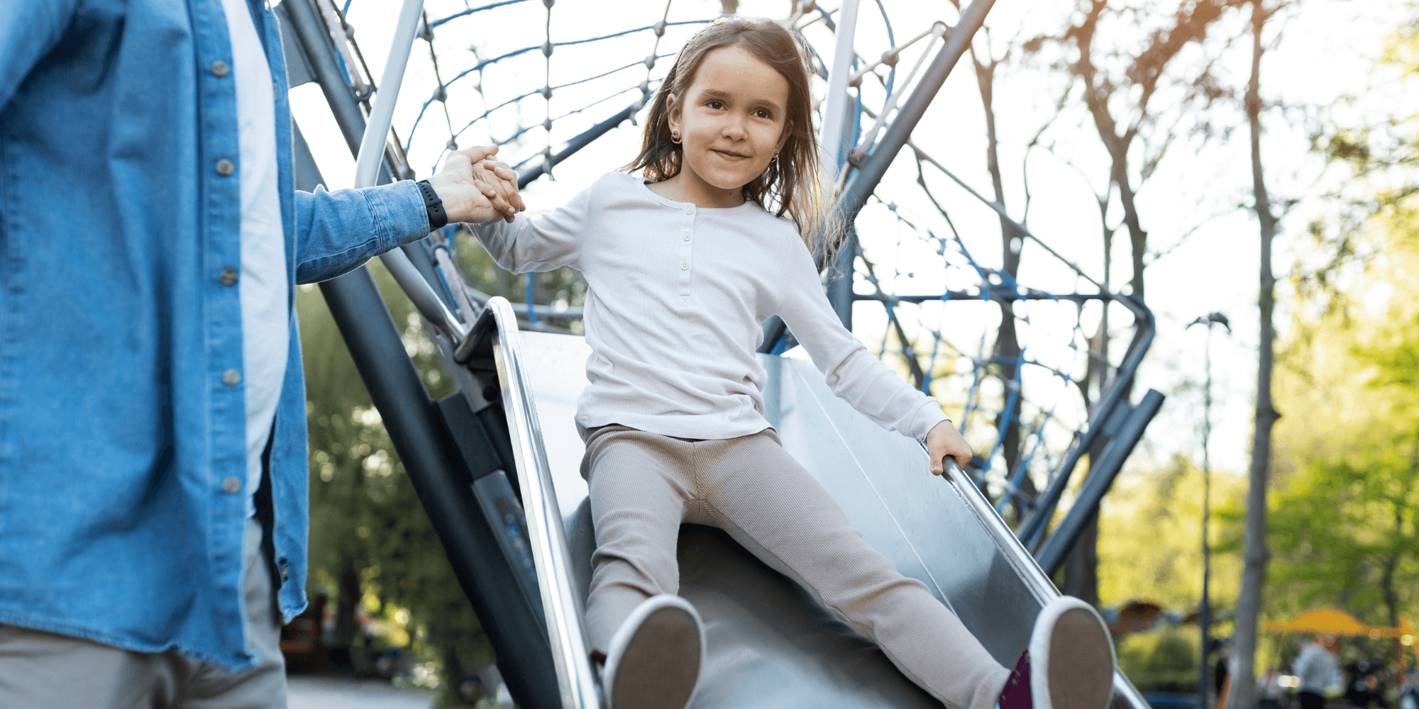 Enfant handicapé et valides jouant ensemble dans une plaine de jeux inclusive en Belgique, symbole d’inclusion et de solidarité familiale."