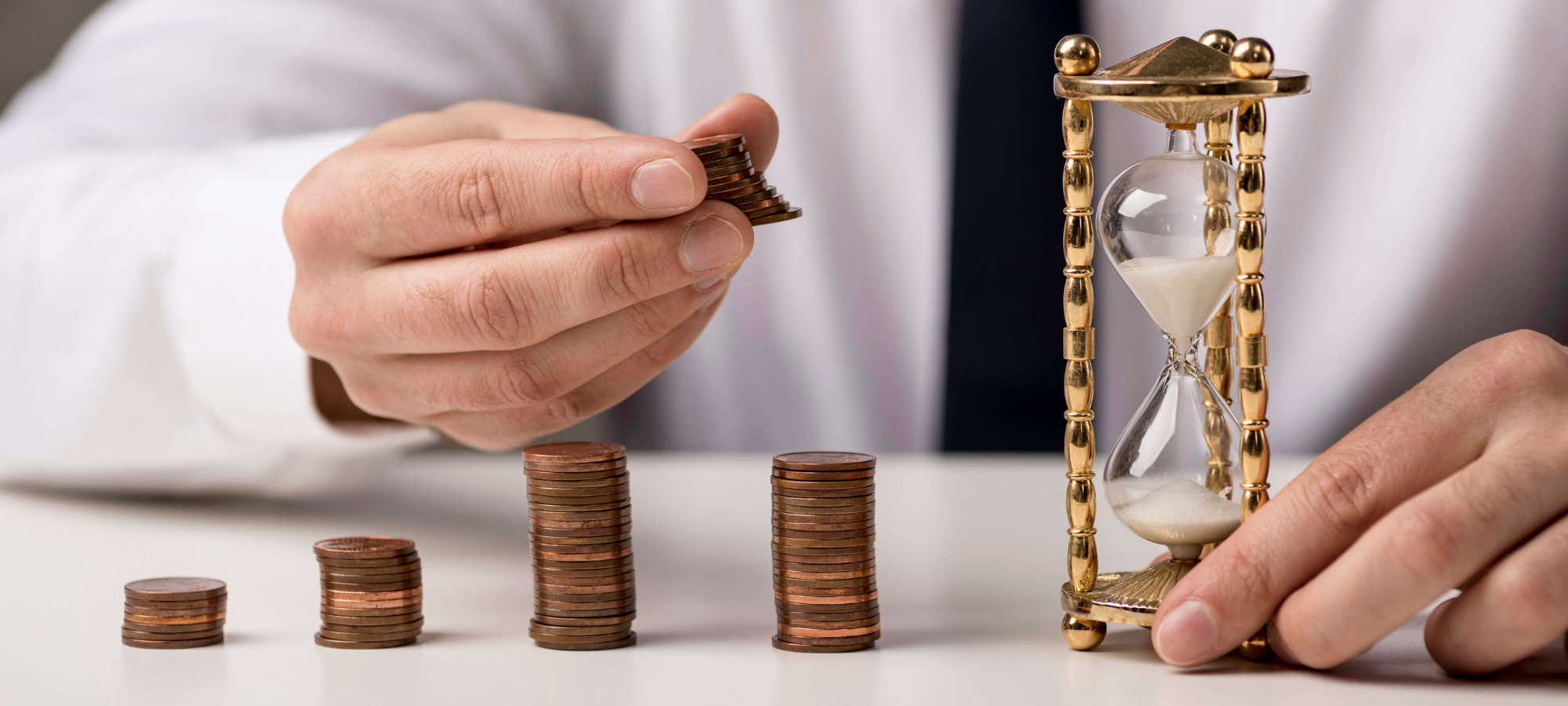 Pièces de monnaie empilées avec un sablier illustrant la réforme du chômage limité et le passage au CPAS en 2026 en Belgique